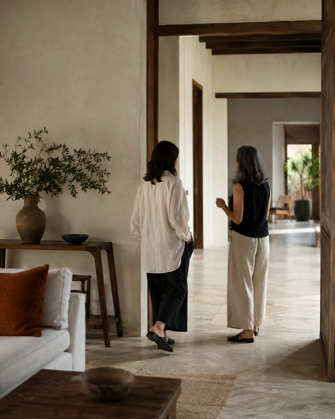 Dos personas caminando y conversando en un espacio cálido